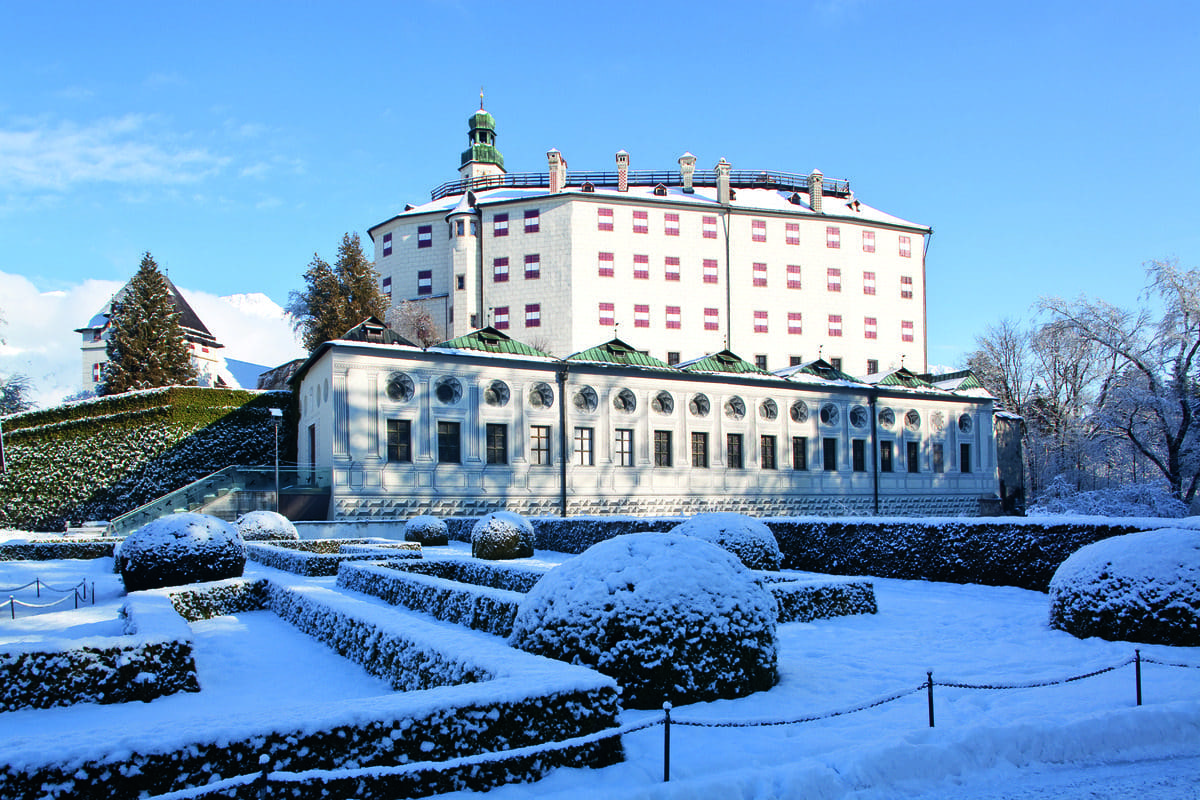 The Ambras Castle sits proudly in the snow, surrounded by snow-dusted gardens, one of the best things to do in Innsbruck with kids this winter.