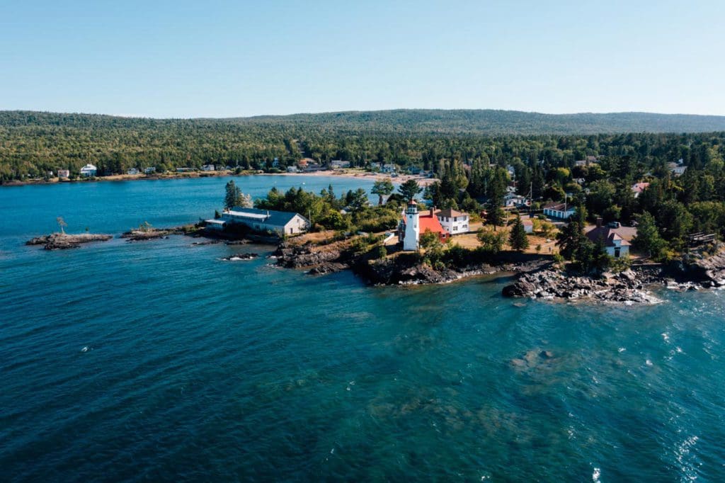 An aerial view of the Eagle Harbor Lighthouse on Lake Superior, one of the best lakes in Michigan for a family vacation.