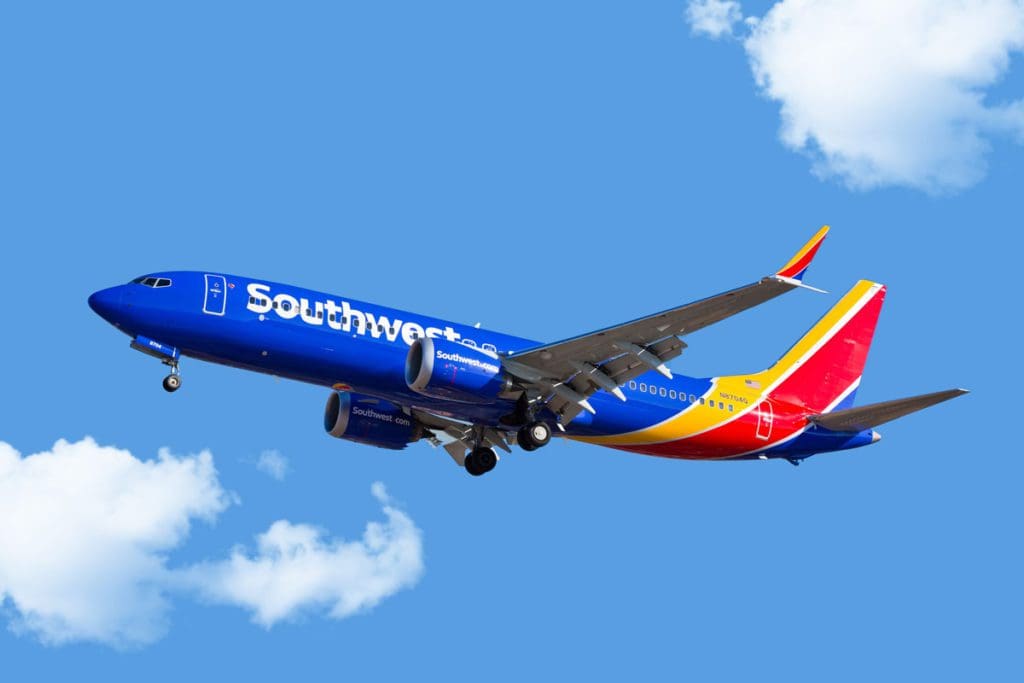 A Southwest Airline plane mid-flight amongst the clouds.