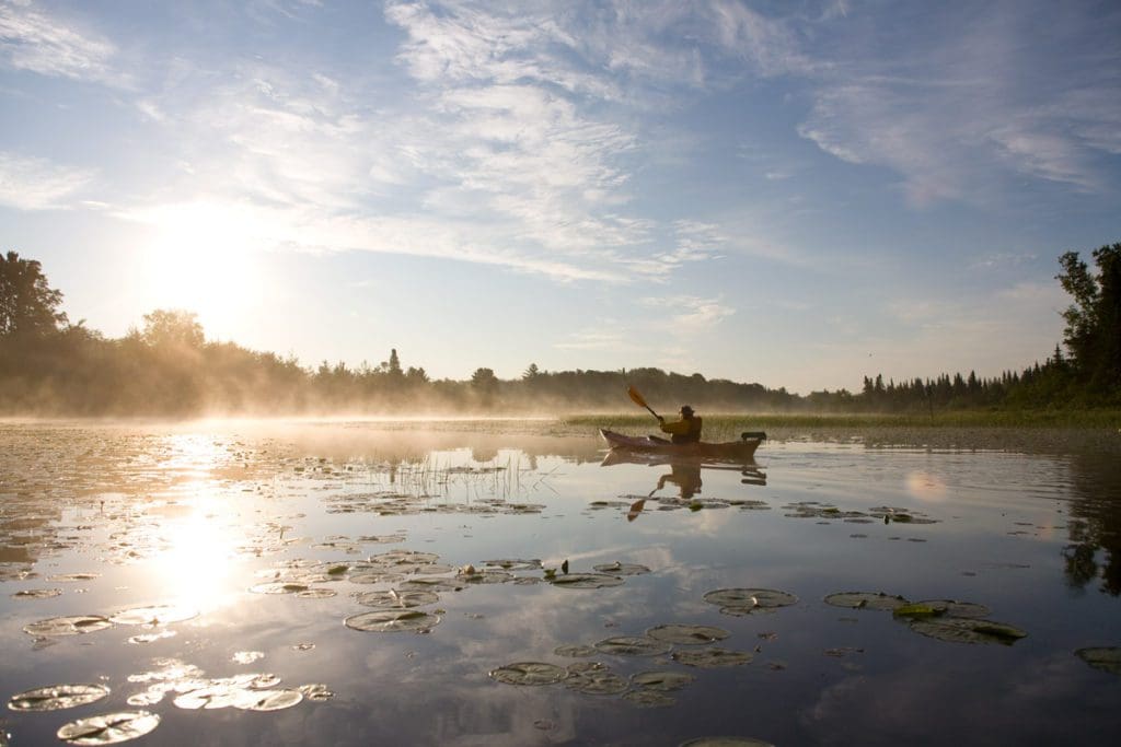 A man paddles a canoe across Lake Namekagon.