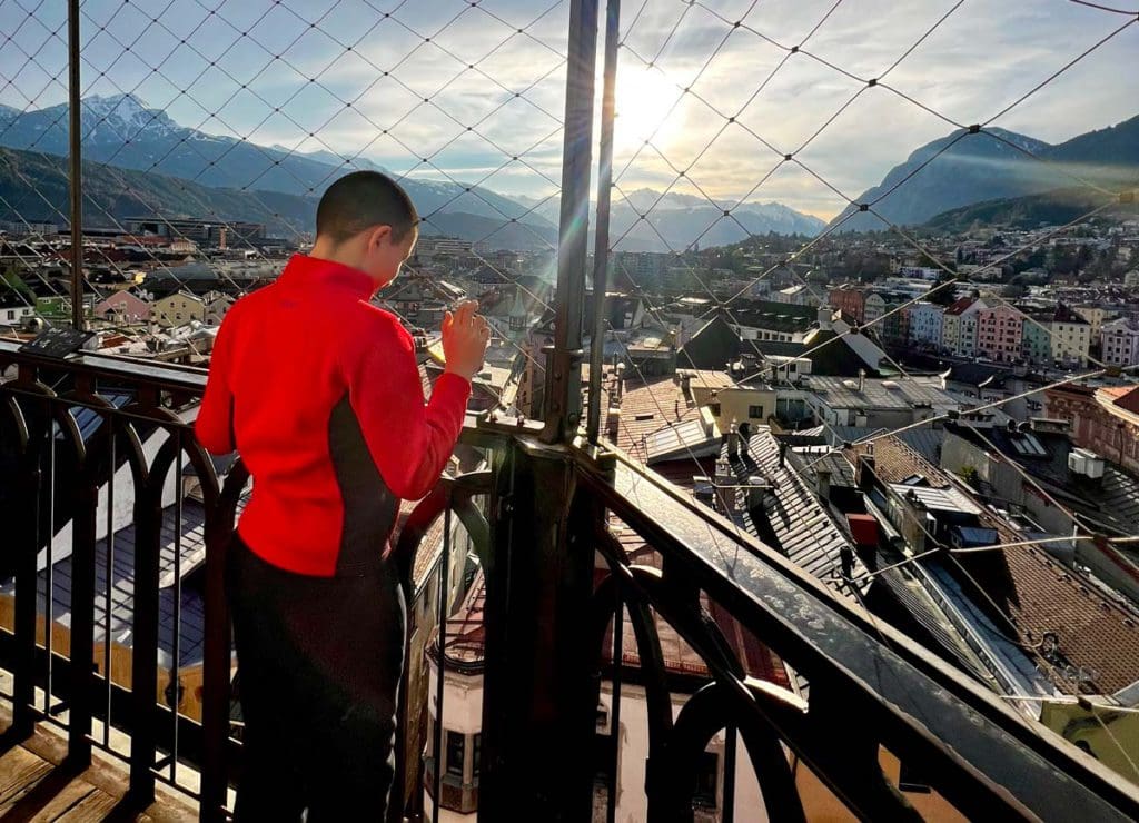 A young boy looks out onto a sweeping view of Innsbruck from the View from the Top Tower of Innsbruck.