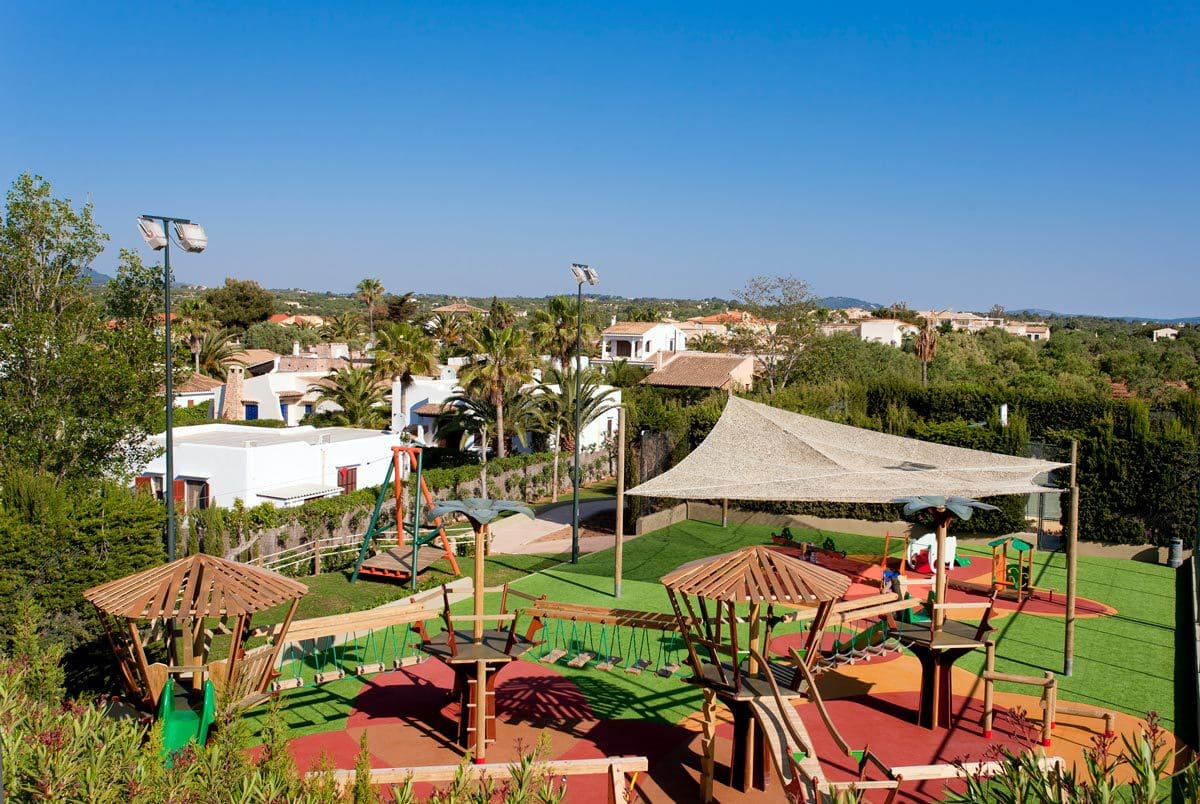 A shaded green space, with guests relaxing at Insotel Cala Mandia Resort & Spa, one of the best all-inclusive hotels in Mallorca for families.