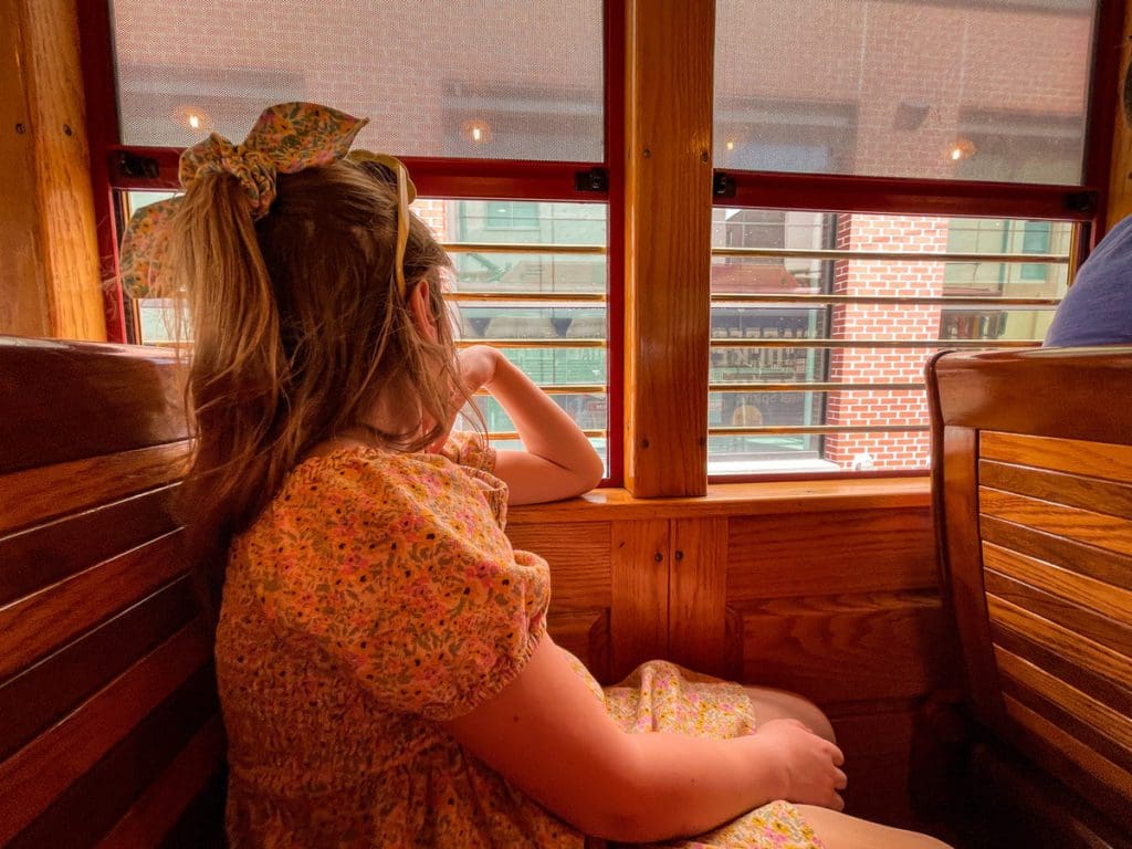 A young girl looks out the window, while riding the TECO Street Car, one of the best things to do in Tampa Bay with kids.