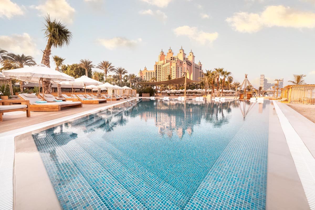 A large pool with resort buildings in the distance at Atlantis, The Palm, one of the best beachfront hotels in Dubai for families.