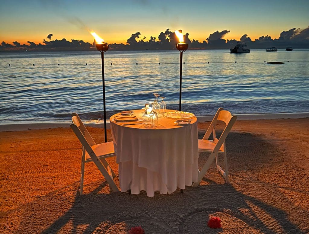 A table is set for a candle-lit dinner for two on the beach in Jamaica.