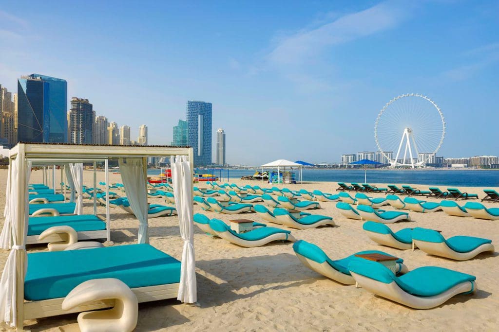 Several beach loungers and cabanas on the beach at Habtoor Grand Resort, Autograph Collection.