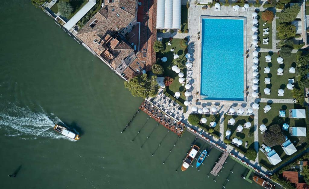 Aerial view of a boat passing by the ground of Hotel Cipriani, A Belmond Hotel, Venice.