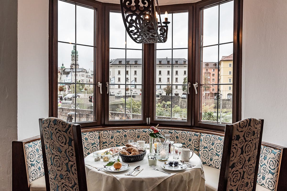 A table set for breakfast with a view of the Innsbruck city center at Hotel Mondschein, one of the best hotels in Innsbruck for families.
