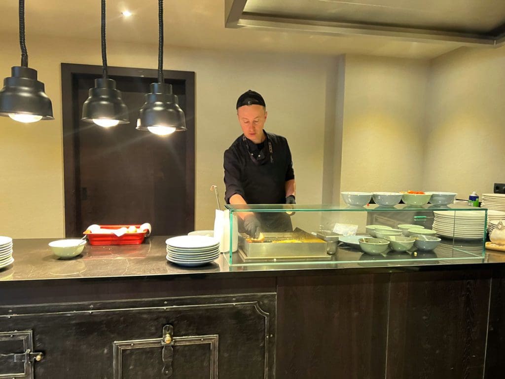A man grabs food from an omelette station at Hotel Mooshaus.
