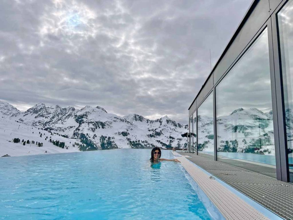 A woman swims in a lovely adult-only, outdoor hotel pool, just one of the many reasons why families adore Hotel Mooshaus for a family ski vacation in Austria.