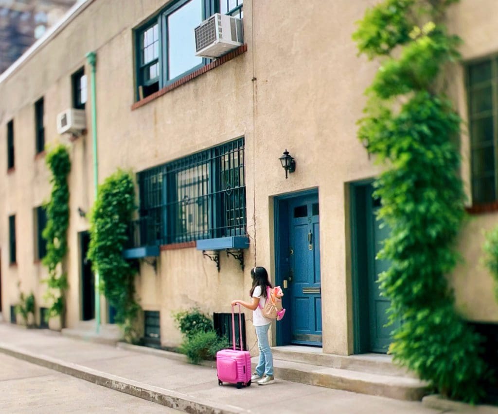 A young girl stands near a hotel entrance with her BÉIS Kids Roller.