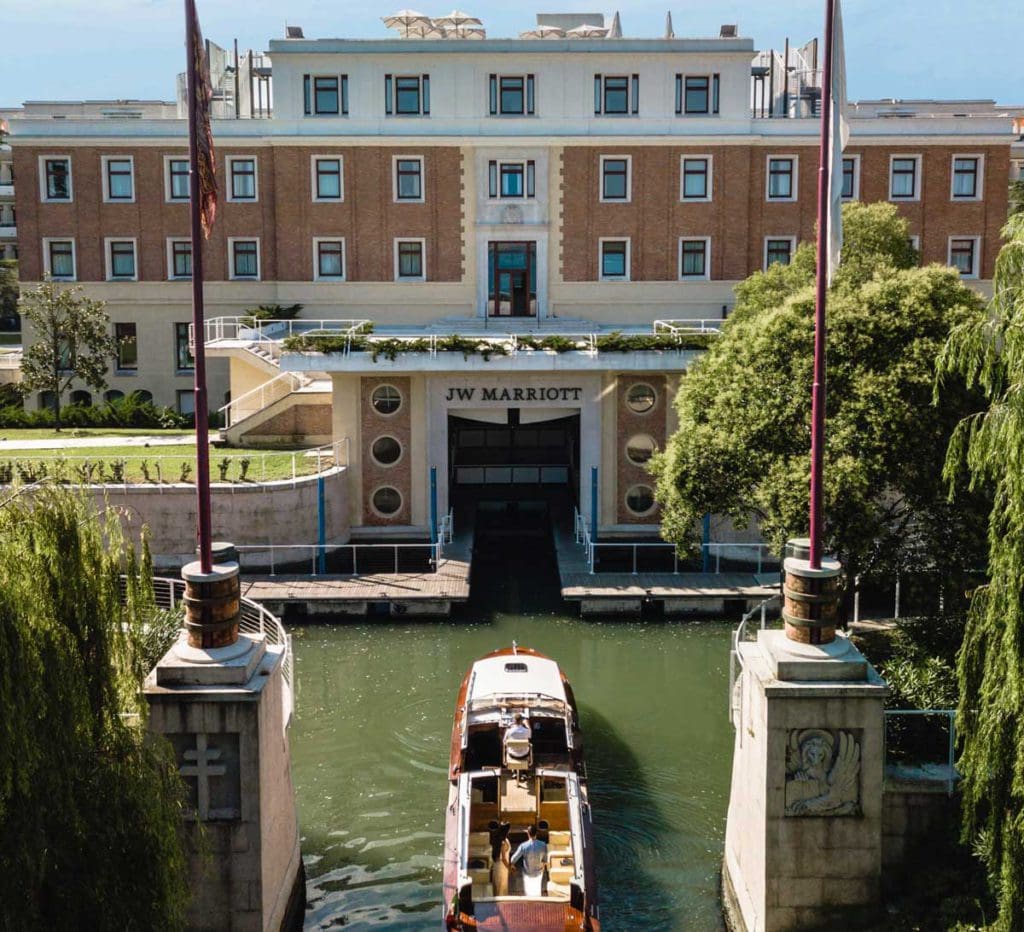 A boat traveling the canals of Venice to the entrance of JW Marriott Venice Resort & Spa, one of the best hotels in Venice for families.