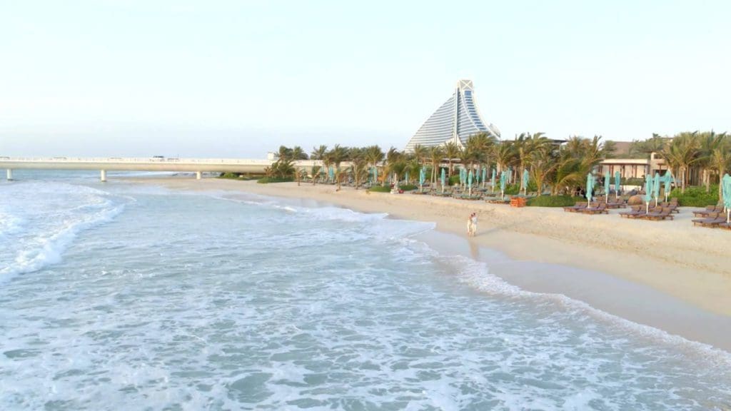 A couple walks along the beach at Jumeirah Zabeel Saray.