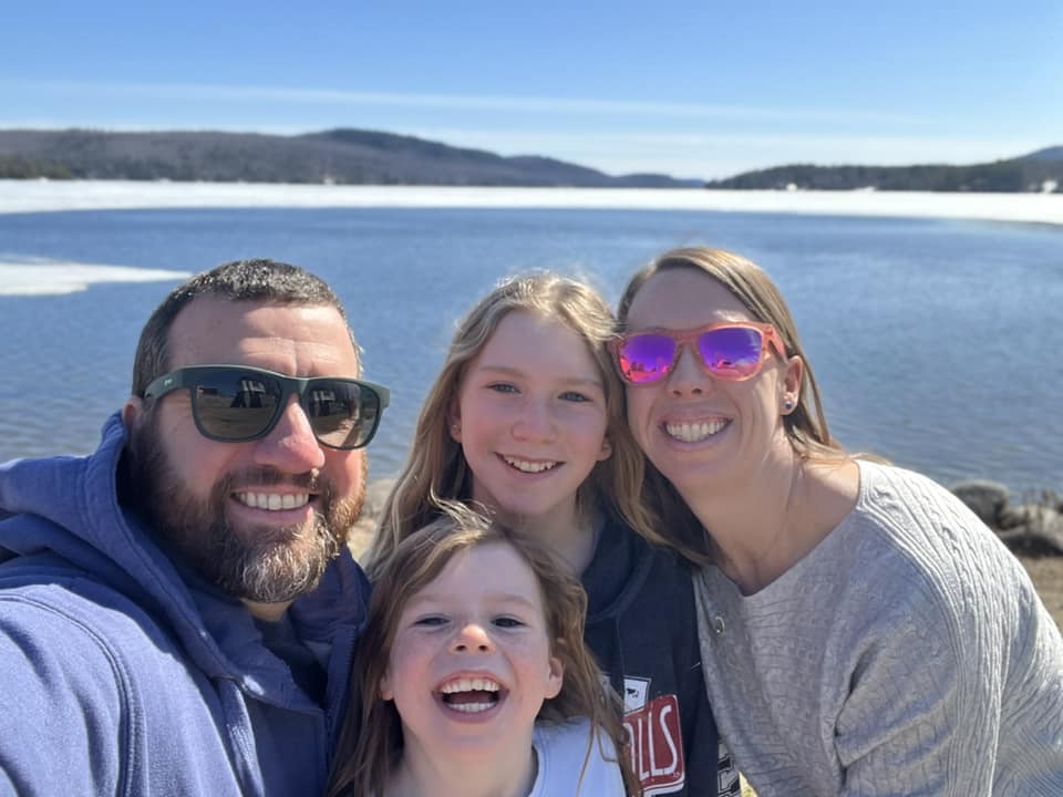 A family smiles together while enjoying a day on Schroon Lake, one of the best lakes in New York State for families.