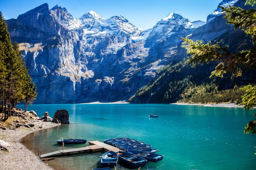 Lake Oeschinensee surrounded by mountains on a clear day, a fun stop on any Switzerland itinerary with kids.