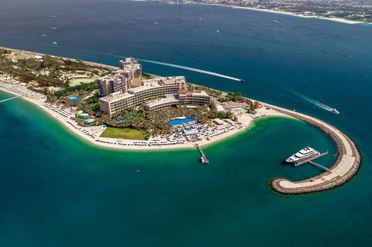 An aerial view of Rixos The Palm Hotel and Suites, at the top of a peninsula.
