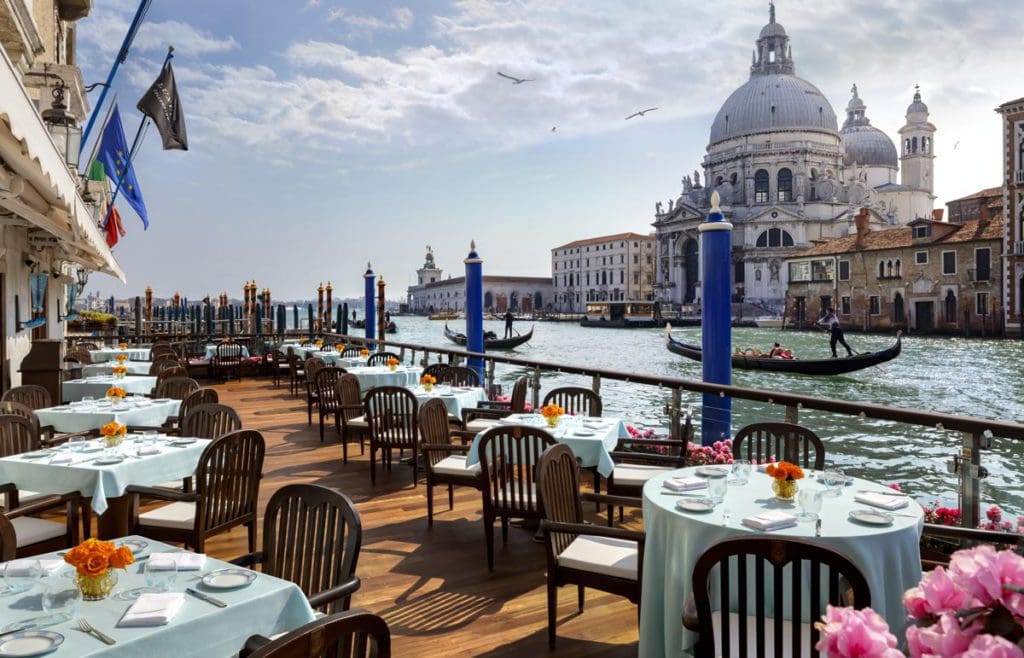 The outdoor terrace with tables set for breakfast with a view of the Grand Canal at The Gritti Palace, a Luxury Collection.