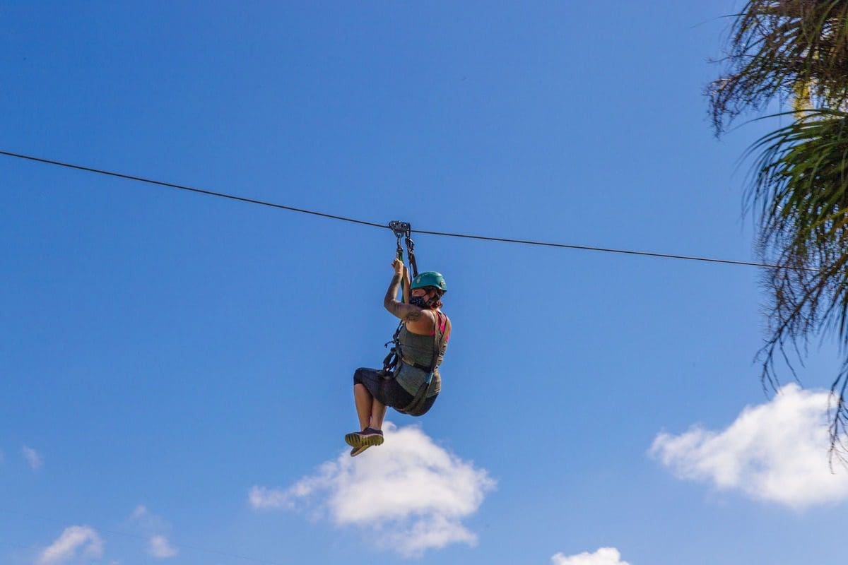 A teen ziplines from tree to tree at Empower Adventures Tampa Bay.