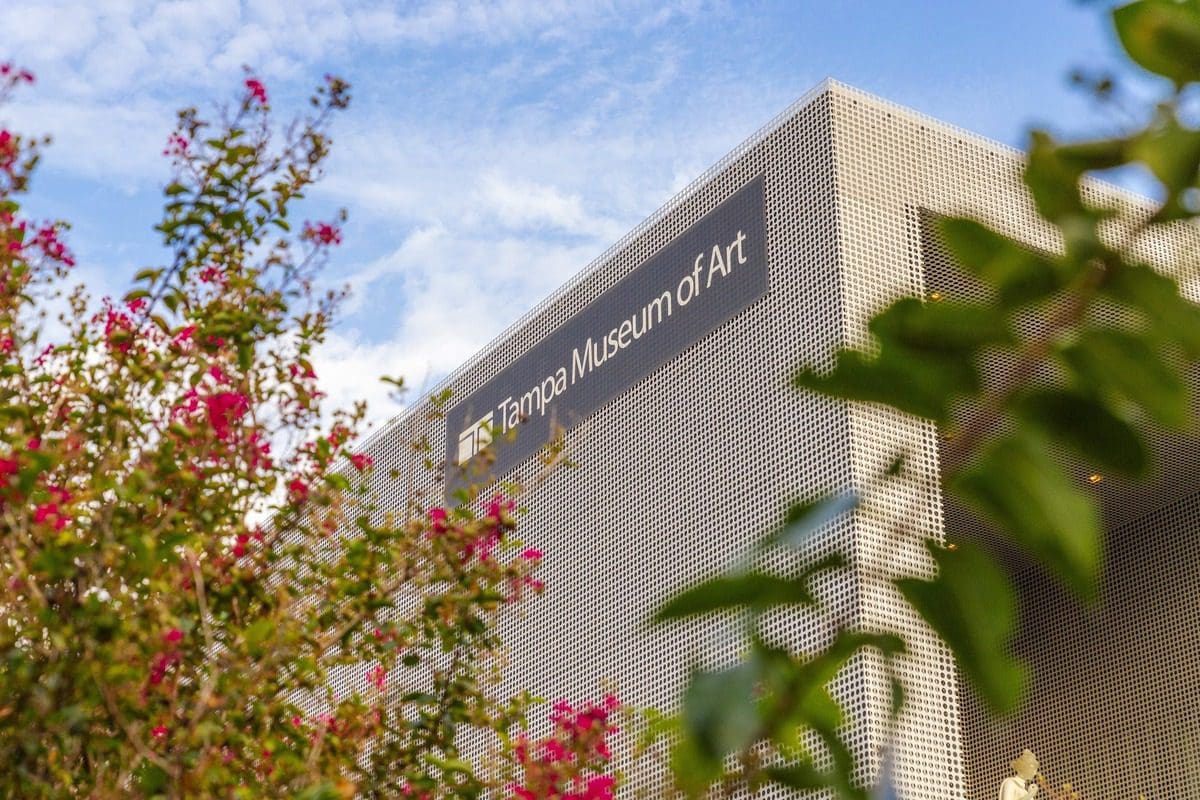 The exterior of Tampa Museum of Art with beautiful flowers framing the sign.