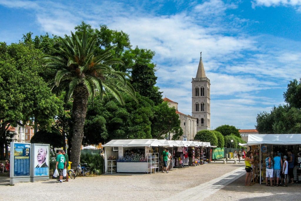 A small market on a street in Zadar, with people shopping.
