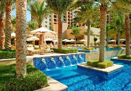 A pool with a small fountain at Fairmont The Palm, one of the best beachfront hotels in Dubai for families.