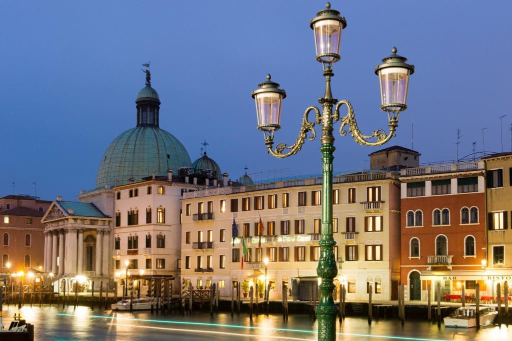 The entrance to Hotel Carlton on the Grand Canal at night, one of the best hotels in Venice for families.