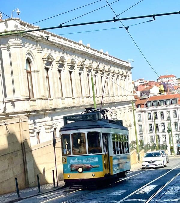 A tram rolling down a street in Lisbon.