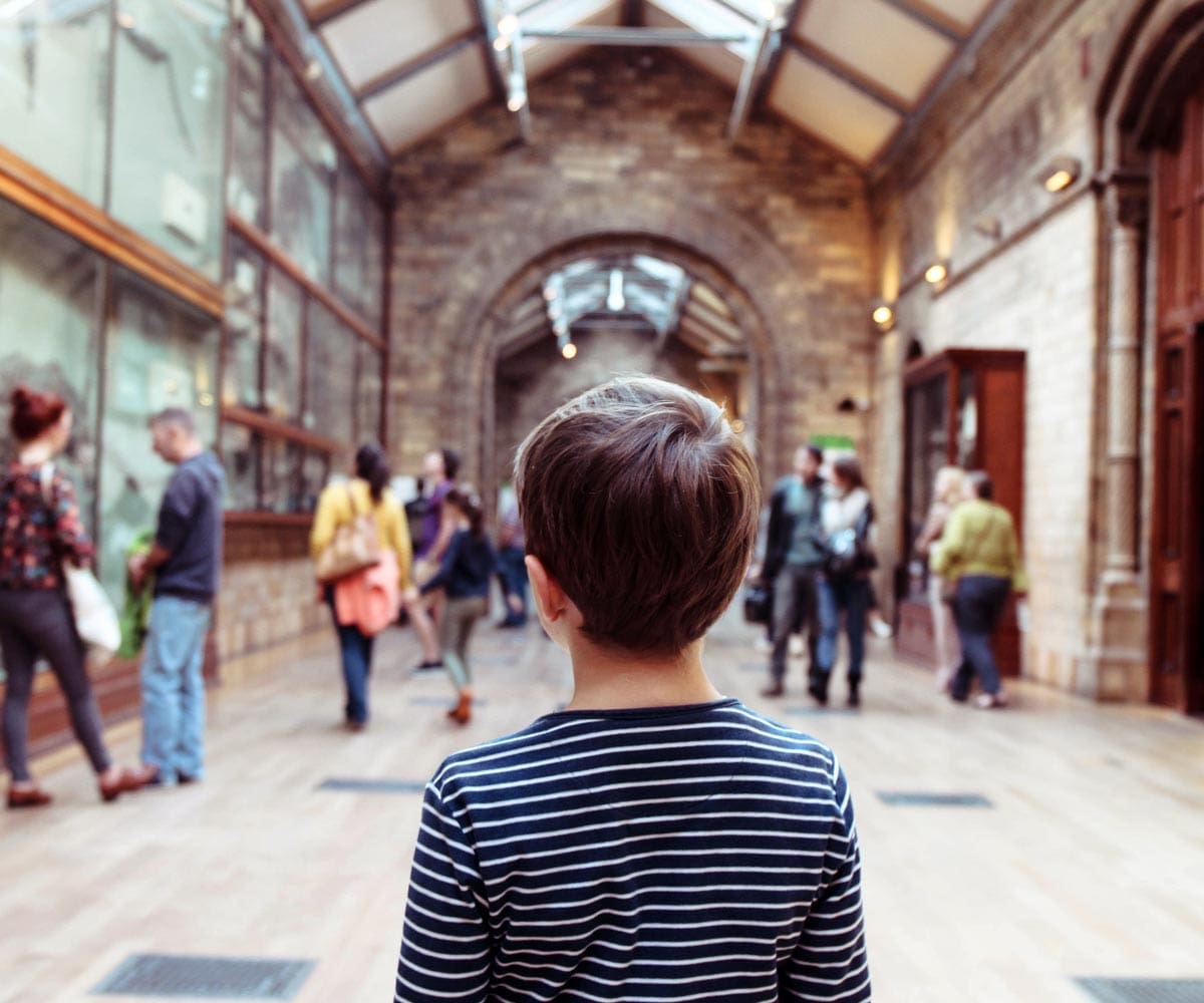 A young boy looks down a gallery hall at the Natural History Museum in London.