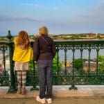 A young girl and her grandmother look over the railing onto a view of the Saint Lawrence River in Quebec City, a must see on any Quebec City itinerary with kids.