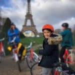 A young boy in front of the Eiffel Tower in Paris on a Fat Bike Tour.