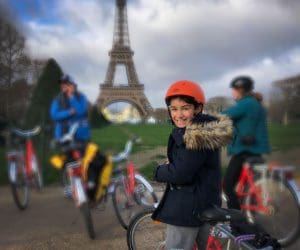 A young boy in front of the Eiffel Tower in Paris on a Fat Bike Tour.