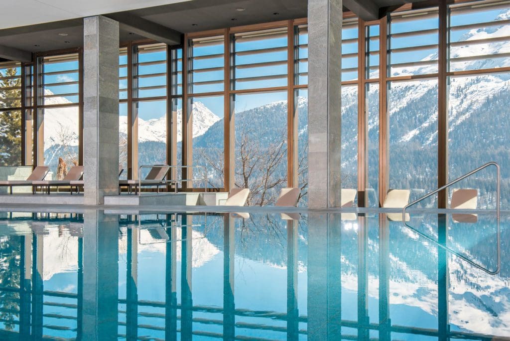 The indoor spa pool looking out onto the mountains at Kulm Hotel St. Moritz, one of the best hotels in St. Moritz for families.