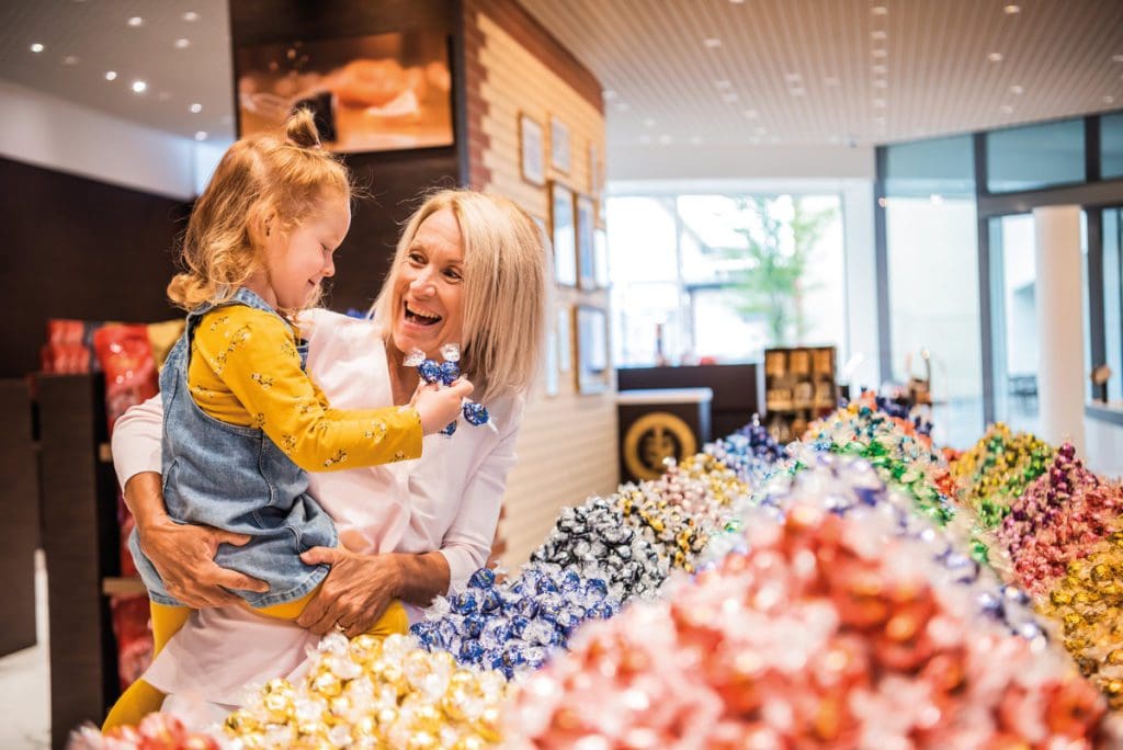 A young girl and her mother enjoy a gift shop full of chocolates at the Lindt Home of Chocolate.