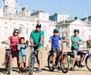 A family of five poses together, while on a bike tour of London.