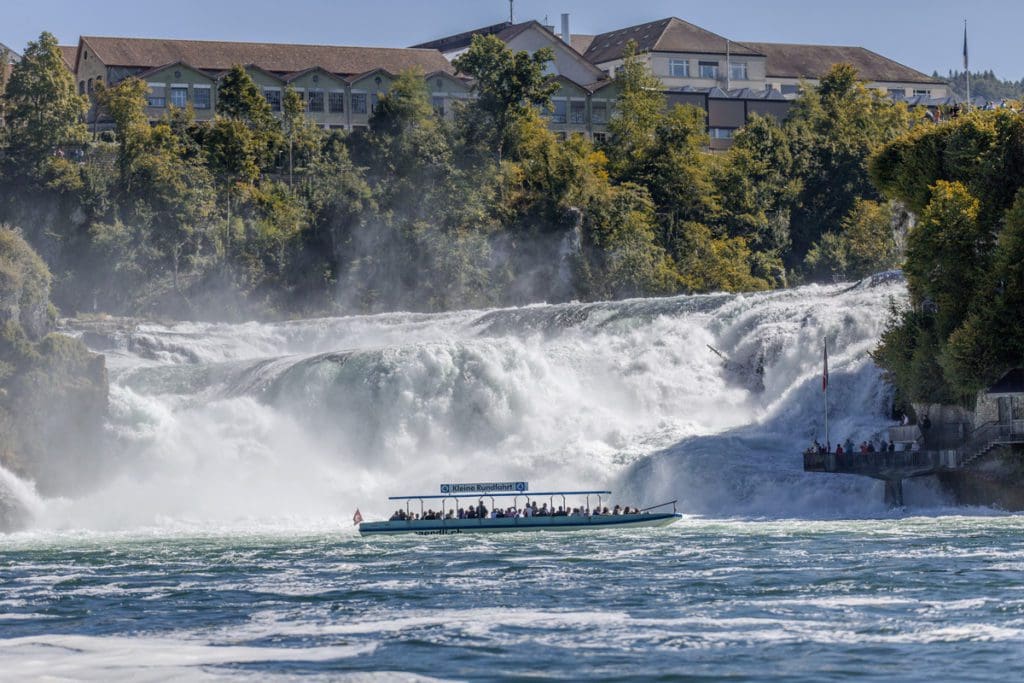 A tour boat moves past Rhine Falls.