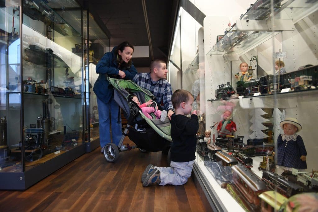 A family of four looks at antique toys at the Zürcher Spielzeugmuseum.