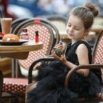 A young girl enjoys a morning at a cafe in Rome.