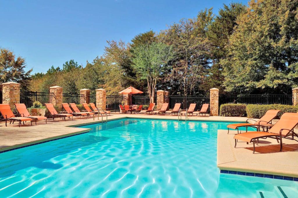The outdoor pool and surrounding pool deck on a sunny day at Atlanta Marriott Alpharetta.