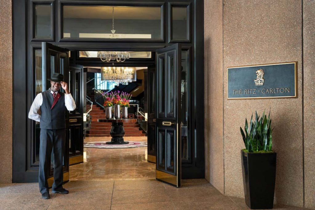 A staff member greets guests at the entrance to The Ritz-Carlton, Atlanta, one of the best hotels in Atlanta for families.