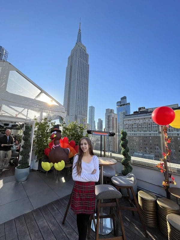 A young girl enjoys a rooftop party for the Macy's Day Parade.