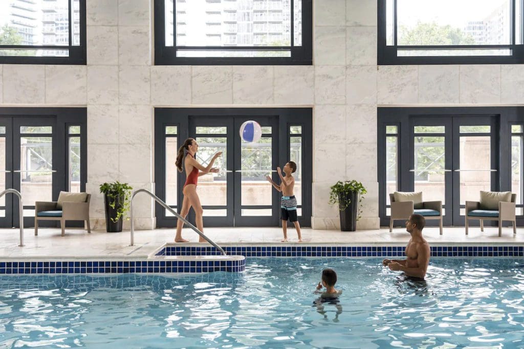 A family of four plays at the pool at Four Seasons Hotel Atlanta.