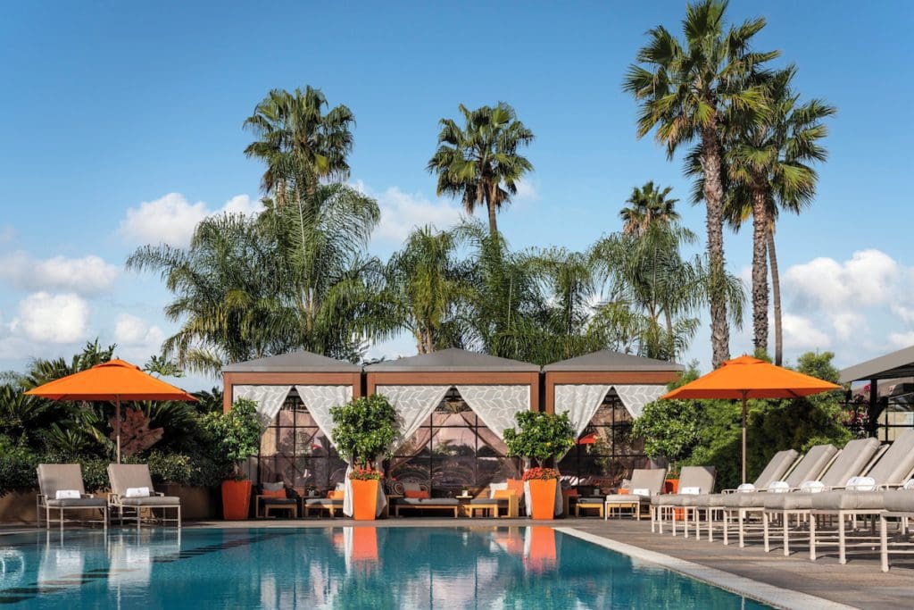 Large cabanas sit at the edge of the outdoor pool at Four Seasons Hotel Los Angeles at Beverly Hills, one of the best hotels in Los Angeles for families.