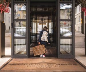 A little boy with a suitcase walks into Grand Hotel Kronenhof.