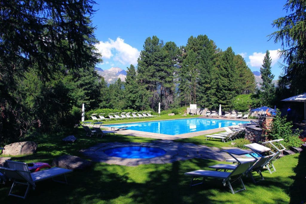 The outdoor pool on a sunny summer day at Hotel Saratz.