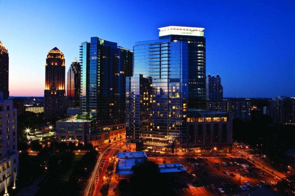 The exterior of Loews Atlanta Hotel at night, along the Atlanta skyline, one of the best hotels in Atlanta for families.