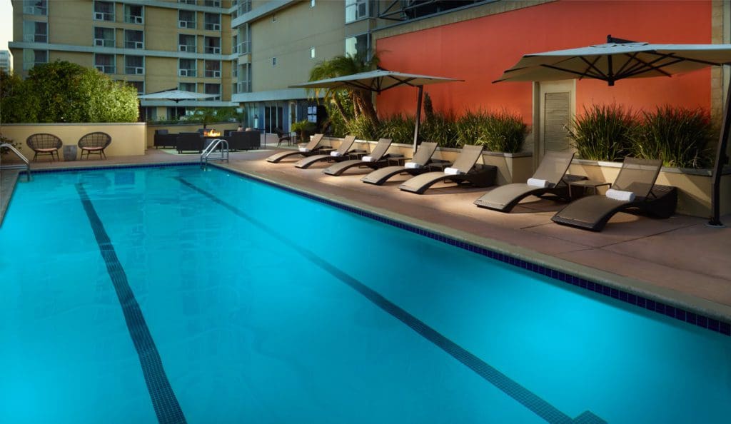 The outdoor pool, with poolside loungers along the edge, at Omni Los Angeles Hotel at California Plaza.