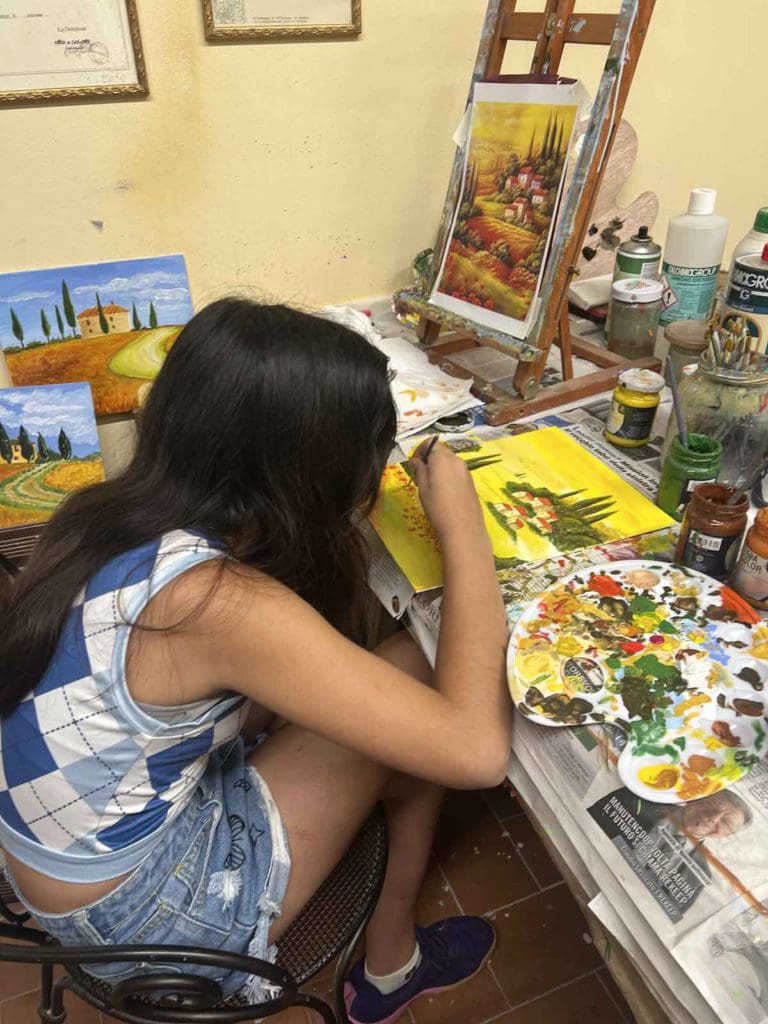 A young girl paints at a an art class in Tuscany.
