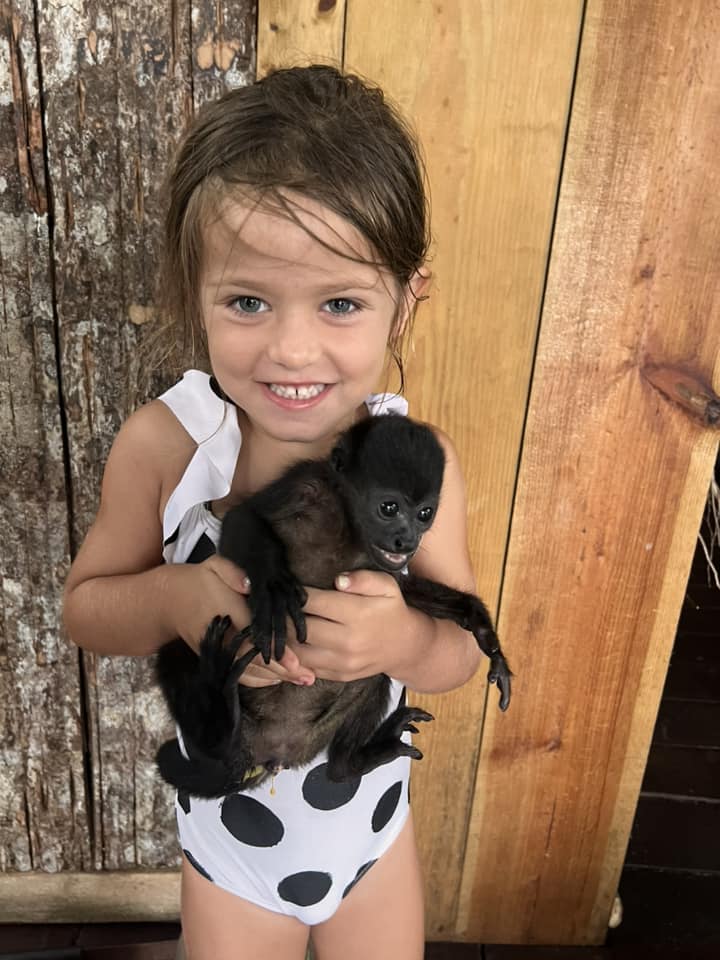A young girl holds a monkey in Panama, one of the best places in South America with kids.