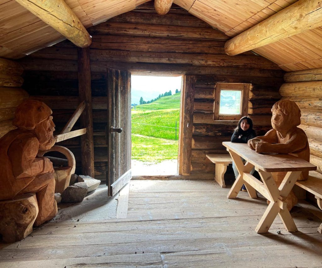 A young girl sits in Heidi's house near St. Moritz, a must on any St Moritz Itinerary with kids.