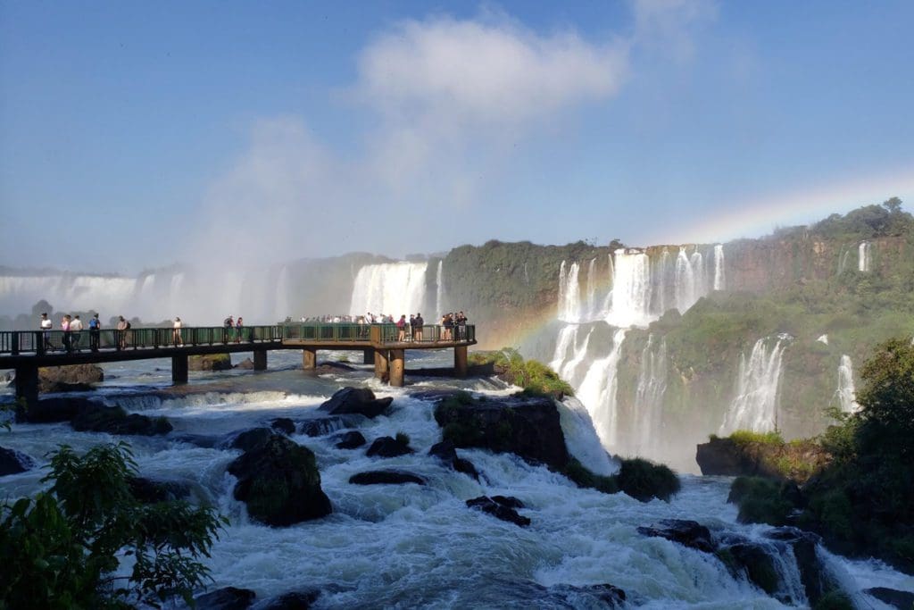 People wander around a platform, enjoying views of Iguazu Falls.